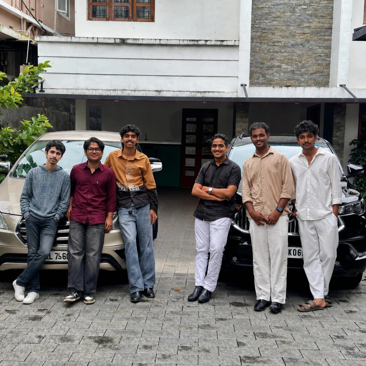 The GRAPPY team standing together outdoors in front of two cars